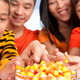 Family all reaching for candy corn from the same bowl